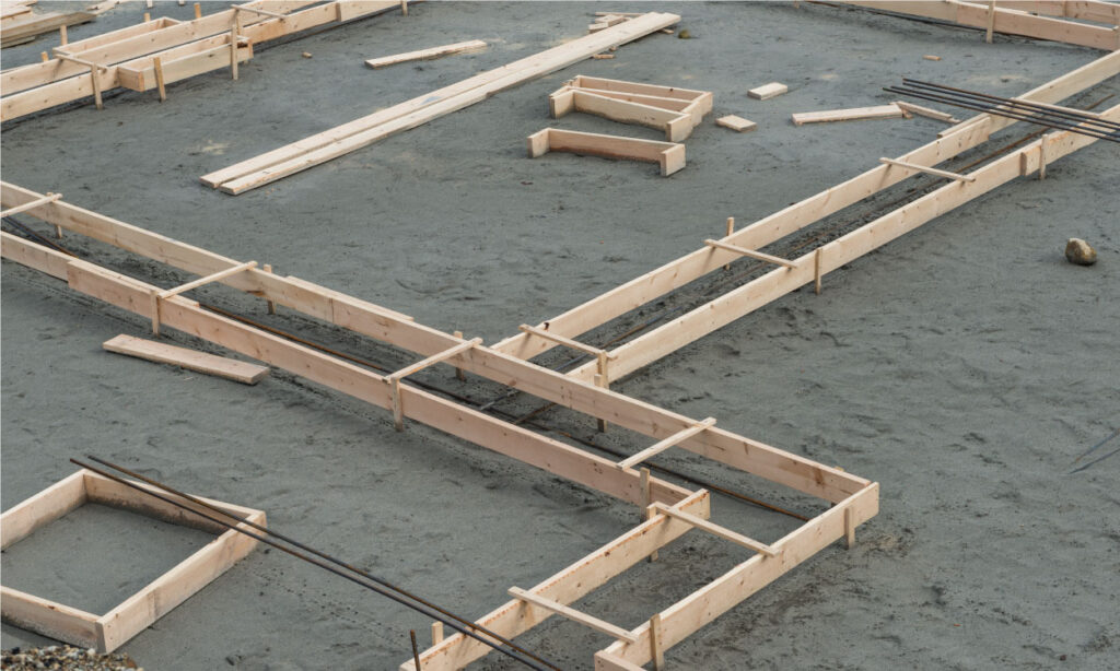 build wooden forms with 2x4s or 2x6s and attach them to wooden stakes around the perimeter